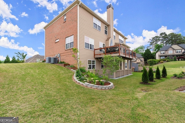 back of house featuring a lawn, central air condition unit, a chimney, and a deck