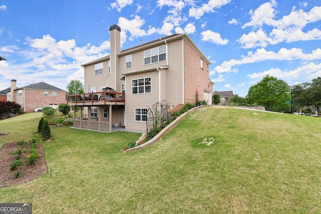 back of house with a lawn, a chimney, and a wooden deck