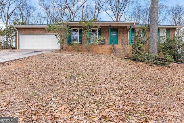 ranch-style house with covered porch, concrete driveway, brick siding, and a garage