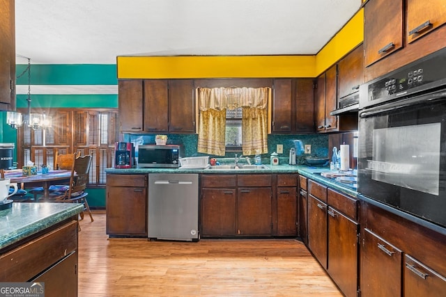 kitchen featuring tasteful backsplash, light wood-style flooring, a sink, appliances with stainless steel finishes, and dark countertops