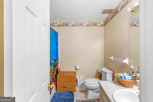 bathroom with a shower with curtain, vanity, tile patterned floors, toilet, and a textured ceiling