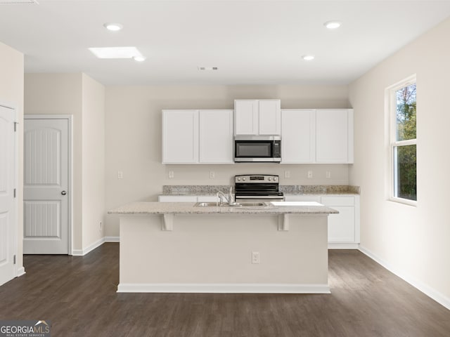 8230 Coldstream Dr, Fairburn, GA 30213 - kitchen with appliances with stainless steel finishes, dark wood-type flooring, light stone counters, a center island with sink, and recessed lighting