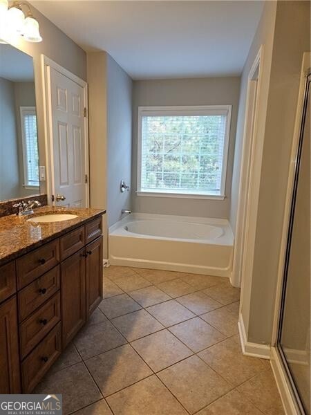 bathroom featuring tile patterned floors, a shower with shower door, a bath, and vanity