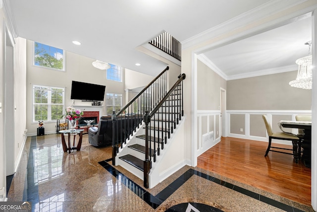 209 Braemar Ct, Mcdonough, GA 30253 - stairs featuring ornamental molding, a fireplace, recessed lighting, granite finish floor, and a notable chandelier