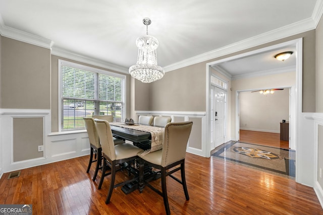 209 Braemar Ct, Mcdonough, GA 30253 - dining space featuring an inviting chandelier, wood finished floors, visible vents, and a decorative wall