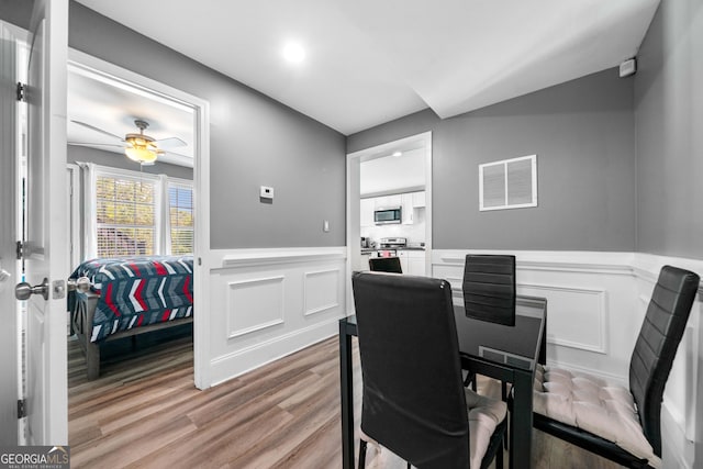 209 Braemar Ct, Mcdonough, GA 30253 - dining area with visible vents, wainscoting, wood finished floors, and a decorative wall