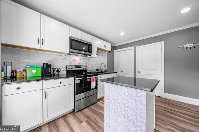 209 Braemar Ct, Mcdonough, GA 30253 - kitchen featuring light wood-style floors, appliances with stainless steel finishes, white cabinets, and tasteful backsplash