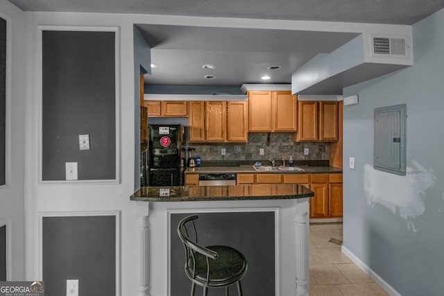3162 Citrus Ct, Decatur, GA 30034 - kitchen featuring backsplash, electric panel, visible vents, black refrigerator, and a peninsula