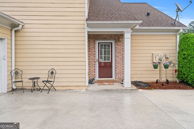 property entrance featuring a shingled roof