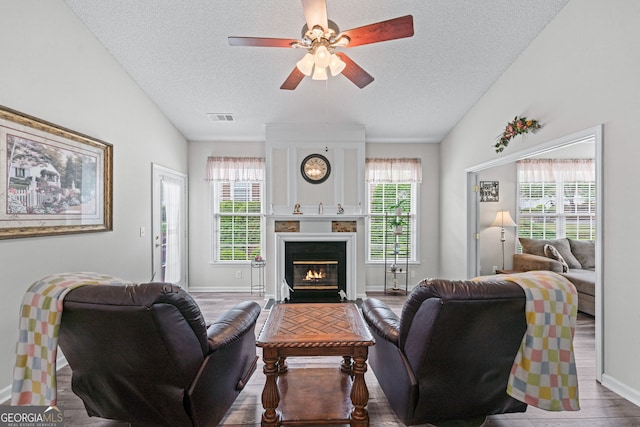 living room with visible vents, a healthy amount of sunlight, and a textured ceiling