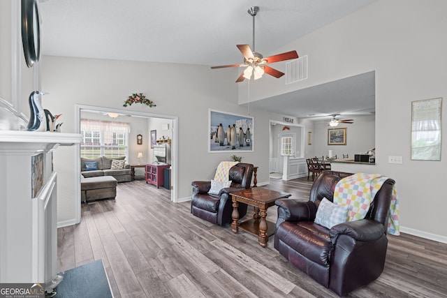 living room with visible vents, wood finished floors, and ceiling fan