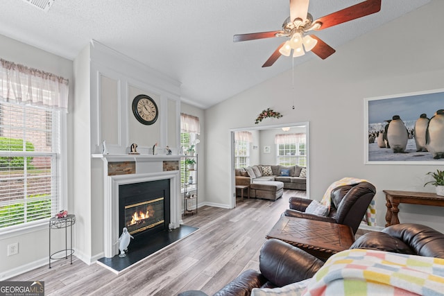living room with a ceiling fan, light wood-style floors, and a healthy amount of sunlight
