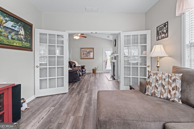 sitting room featuring ceiling fan, vaulted ceiling, wood finished floors, and baseboards