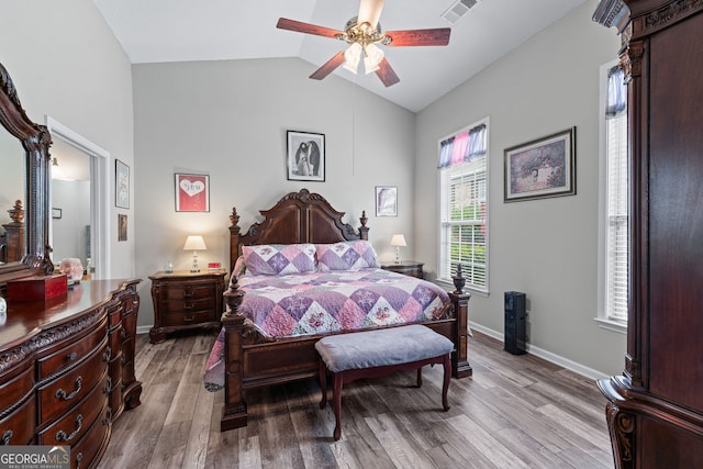 bedroom featuring lofted ceiling, wood finished floors, visible vents, and baseboards