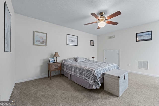 carpeted bedroom with a textured ceiling, visible vents, ceiling fan, and baseboards