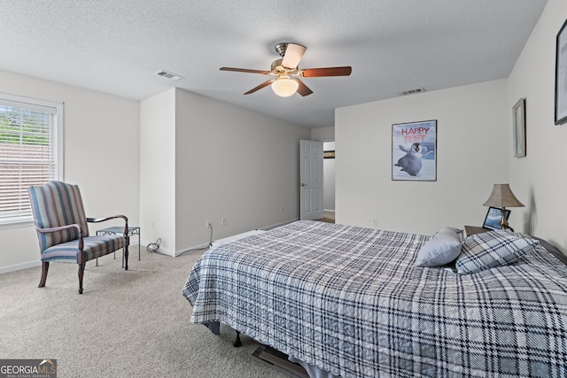 bedroom with visible vents, a textured ceiling, and carpet flooring