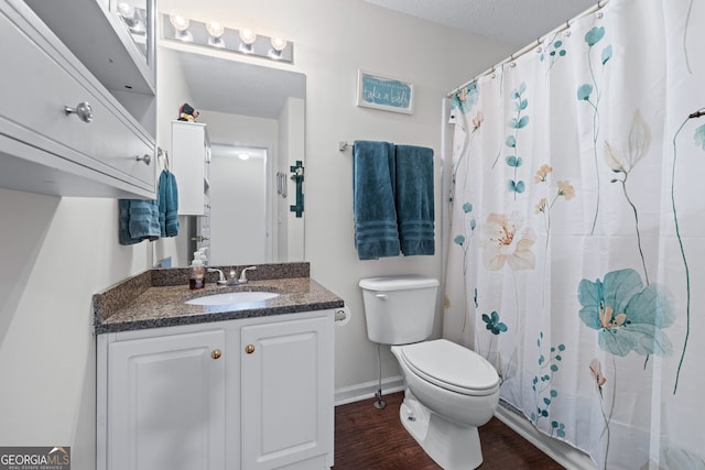 bathroom featuring wood finished floors, a shower with curtain, toilet, vanity, and baseboards