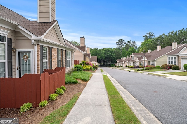 view of street with a residential view, sidewalks, and curbs