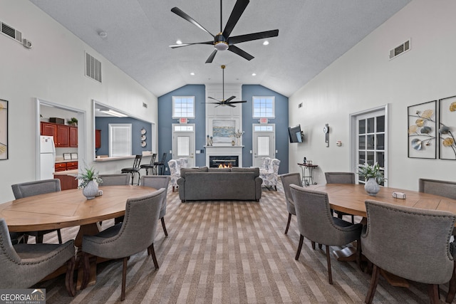 dining space featuring a ceiling fan, high vaulted ceiling, and visible vents