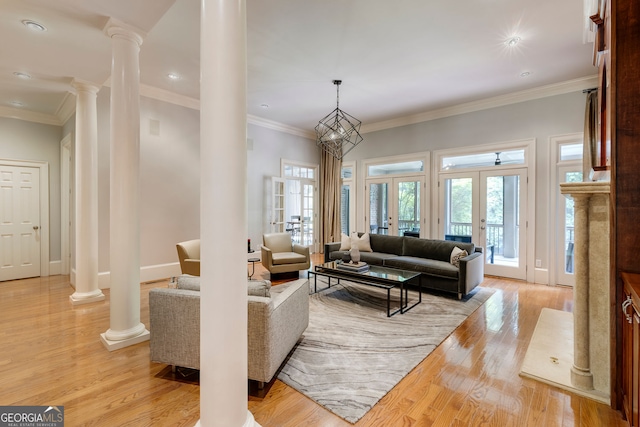 living area with ornate columns, french doors, light wood finished floors, ornamental molding, and baseboards