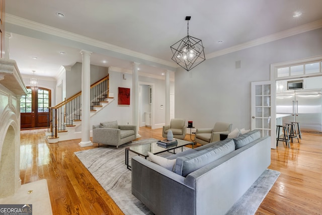 living area featuring light wood finished floors, crown molding, stairway, french doors, and recessed lighting