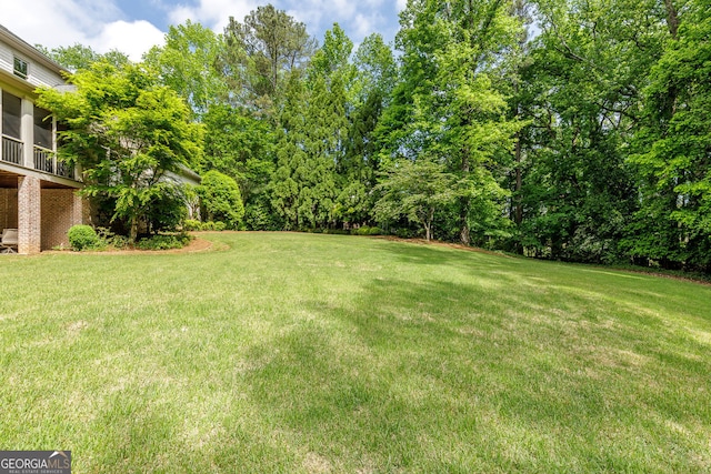 view of grassy yard featuring a sunroom