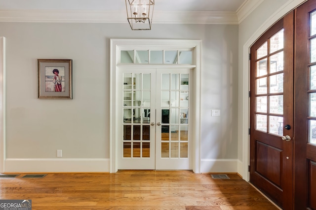 entryway with french doors, ornamental molding, light wood-style floors, and baseboards