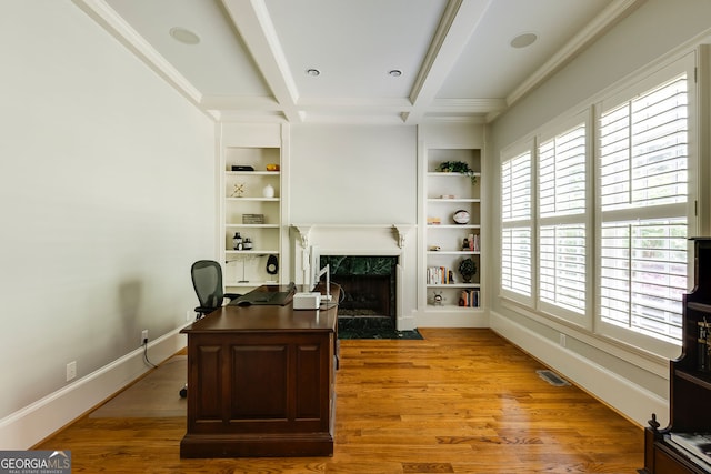 office featuring a fireplace, built in features, light wood-type flooring, beam ceiling, and baseboards
