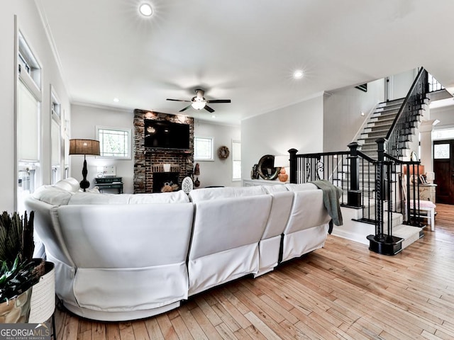 1141 Addington Ln, Waleska, GA 30183 - living area featuring a brick fireplace, wood-type flooring, crown molding, a ceiling fan, and stairs