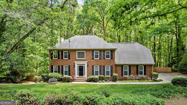 1440 Sandford Trl SW, Lilburn, GA 30047 - colonial-style house with brick siding, a front lawn, fence, and a chimney