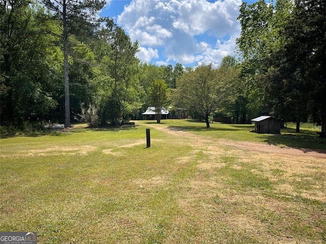 view of community featuring a storage unit, an outbuilding, and a lawn