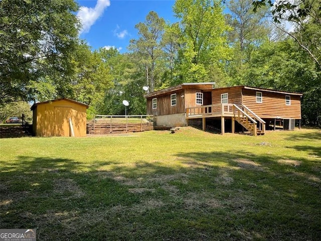 back of property featuring stairs, a yard, and fence