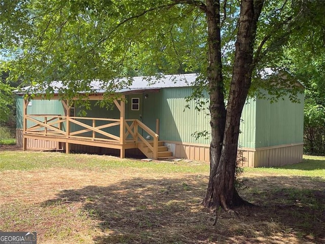 rear view of house with a deck and metal roof