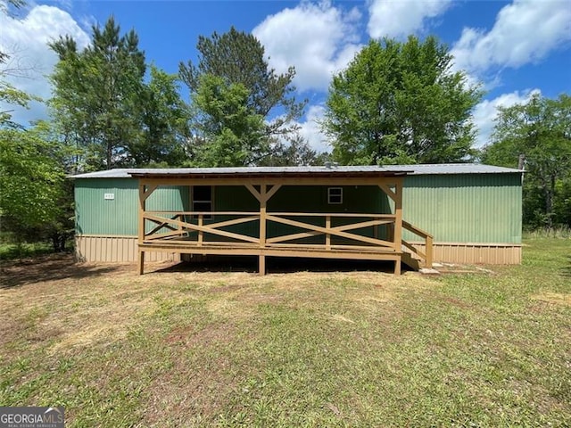 rear view of property featuring a lawn