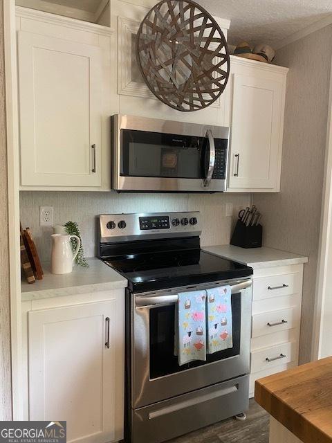 196 SE Stembridge Rd SE, Milledgeville, GA 31061 - kitchen featuring wooden counters, tasteful backsplash, dark wood finished floors, white cabinets, and stainless steel appliances