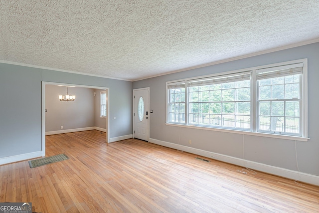 foyer entrance with light wood-style floors, a textured ceiling, visible vents, baseboards, and an inviting chandelier
