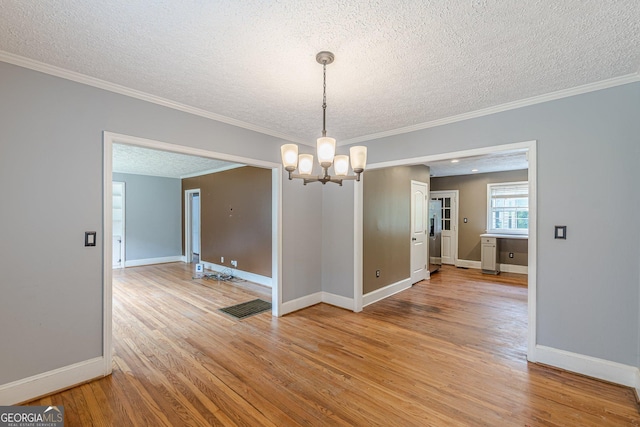 unfurnished dining area with visible vents, a textured ceiling, and light wood finished floors
