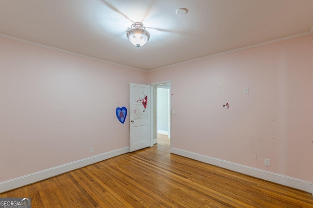 unfurnished room featuring baseboards, ornamental molding, and wood finished floors