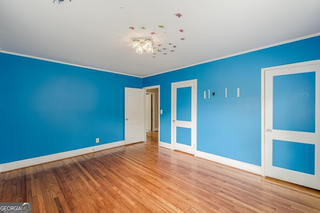 unfurnished bedroom featuring crown molding, baseboards, and wood finished floors