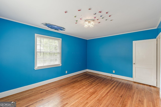 unfurnished room featuring crown molding, baseboards, and wood finished floors