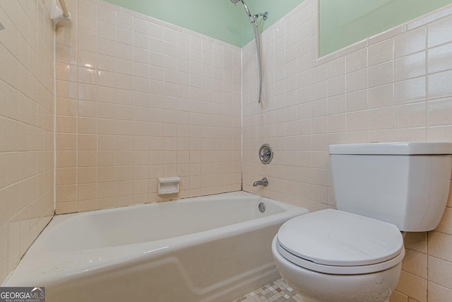 bathroom featuring toilet, tile walls, and shower / bathing tub combination