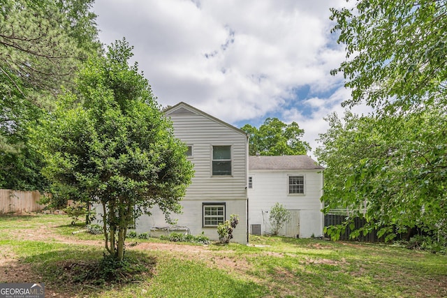 back of property with fence and a yard