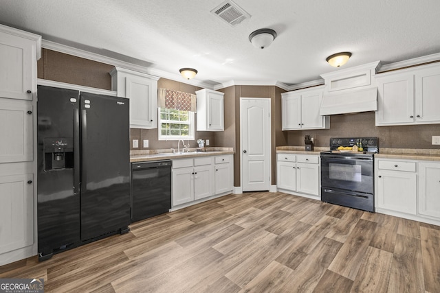 1173 N Ga Highway 21, Springfield, GA 31329 - kitchen with black appliances, premium range hood, white cabinets, light wood-style floors, and ornamental molding