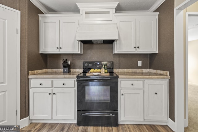 1173 N Ga Highway 21, Springfield, GA 31329 - kitchen featuring black range with electric stovetop, premium range hood, wood finished floors, white cabinetry, and crown molding
