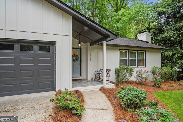 single story home with a chimney, roof with shingles, a front yard, a garage, and concrete driveway