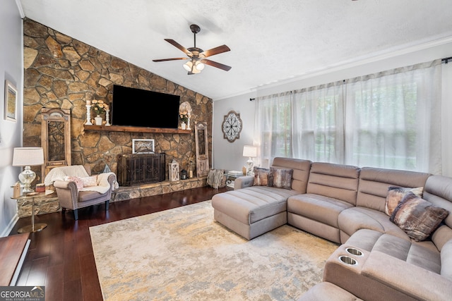 living area featuring wood finished floors, a fireplace, ceiling fan, a textured ceiling, and vaulted ceiling