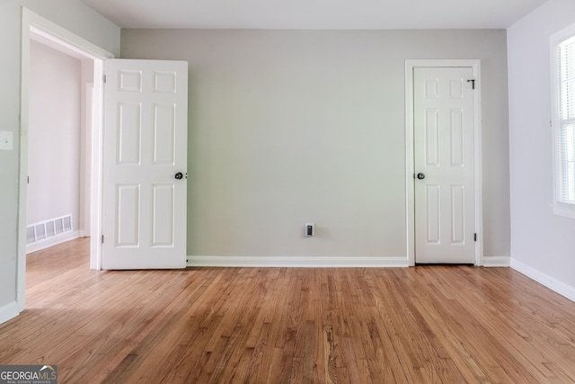 2174 Beecher Rd SW, Atlanta, GA 30311 - unfurnished bedroom featuring light wood finished floors, baseboards, visible vents, and multiple windows