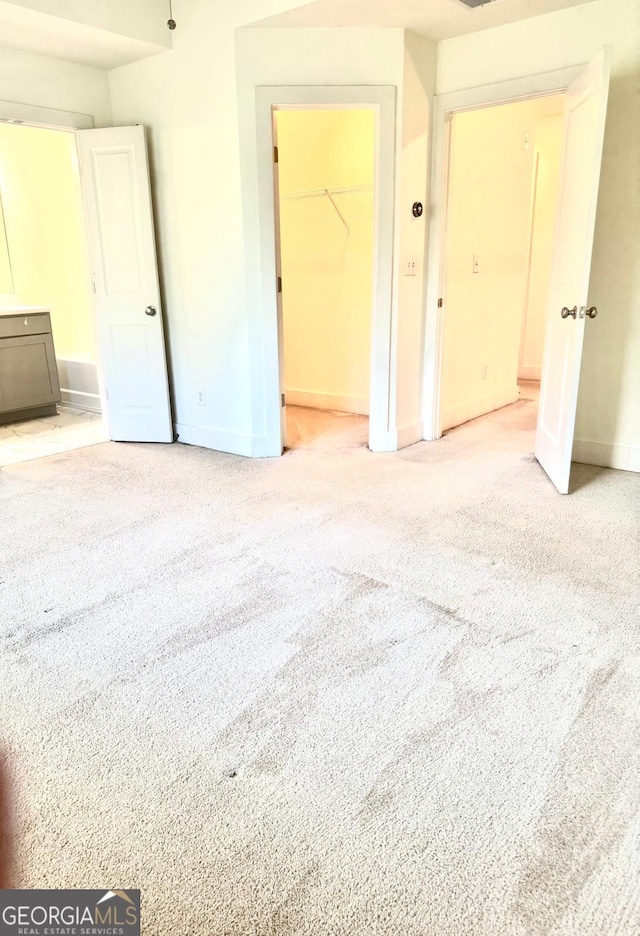 unfurnished bedroom featuring carpet flooring, baseboards, and ensuite bathroom