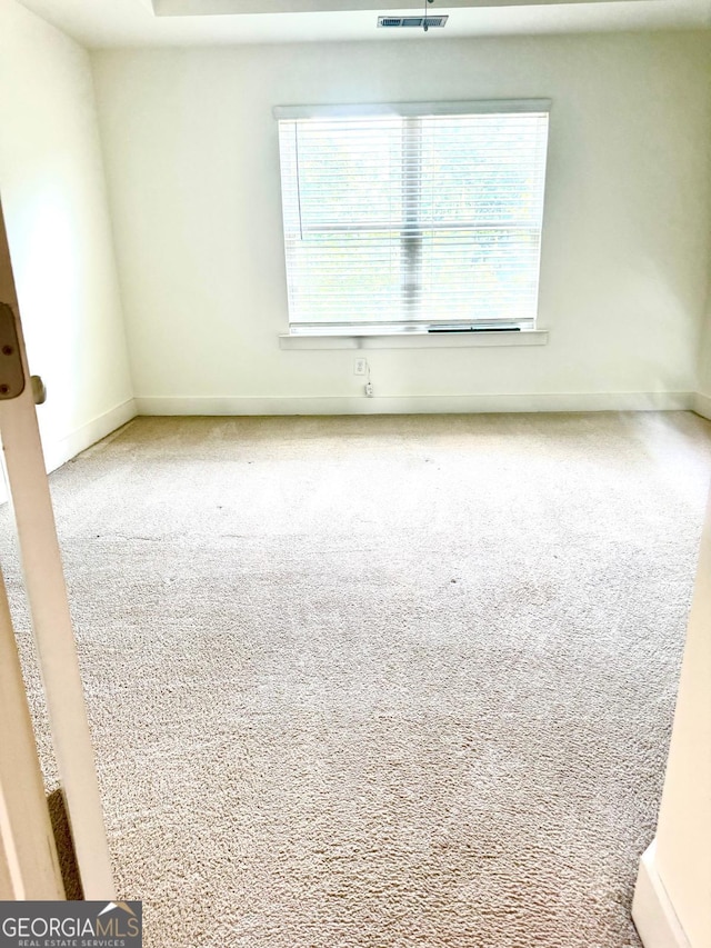 empty room with baseboards and carpet