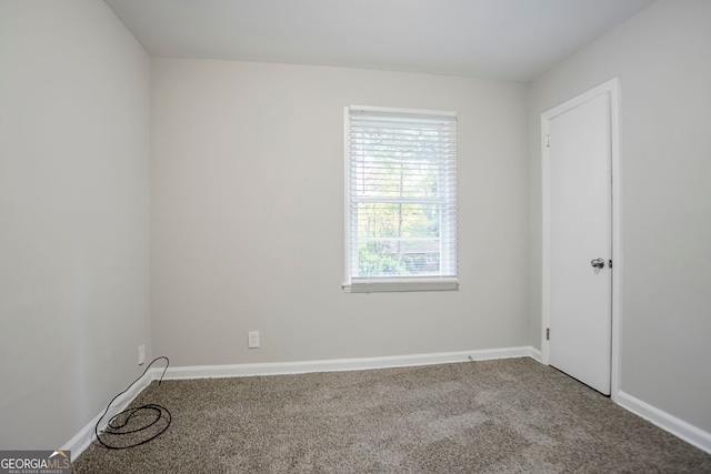 carpeted empty room featuring baseboards